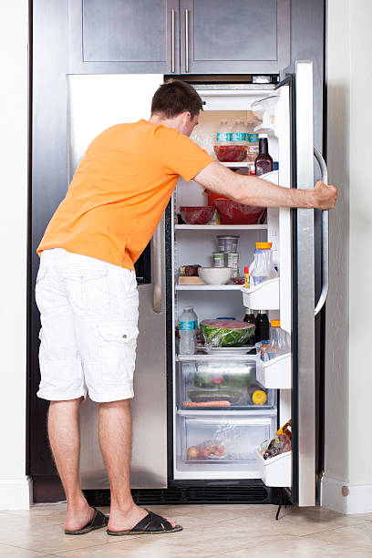 istock Young man looking for food in refrigeretor 487520291