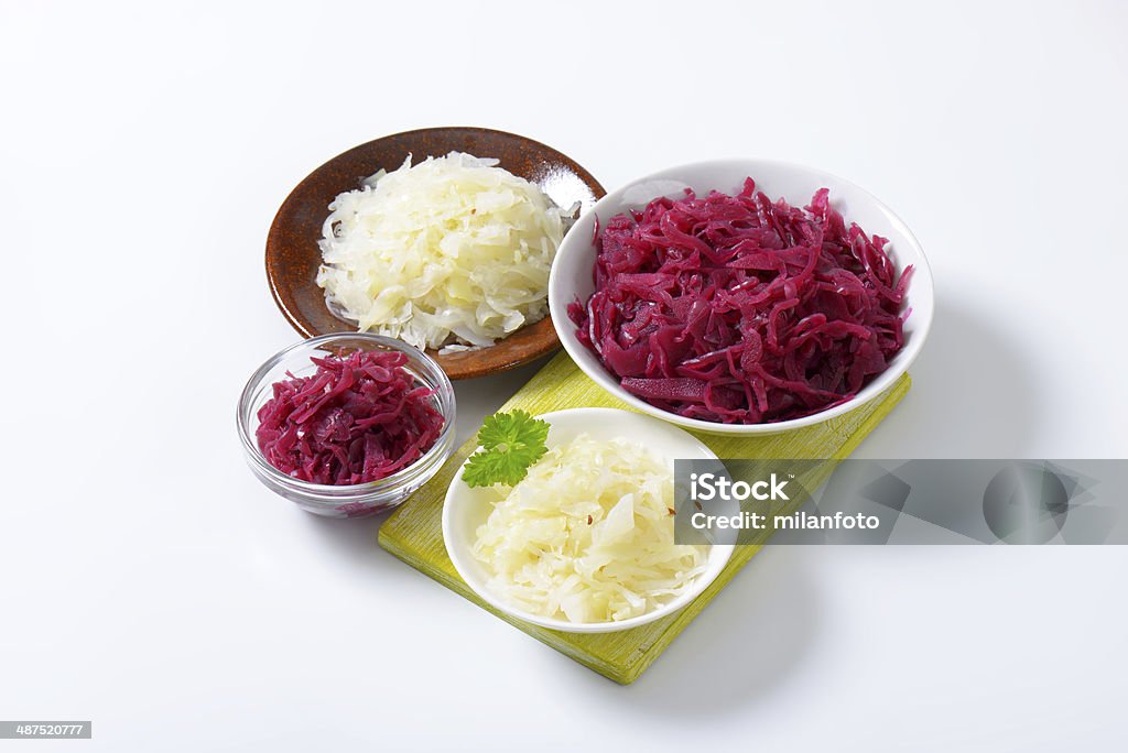 white and red sauerkraut assorted bowls of white and red sauerkrat on wooden cutting board Bowl Stock Photo