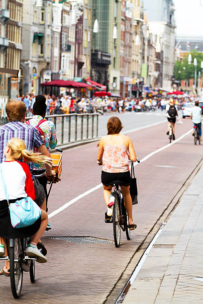 自転車に乗る人のストリート damrak - editorial outdoors vertical amsterdam ストックフォトと画像