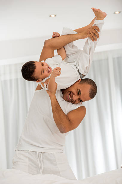 istock Cheerful African American father and son playing in bedroom. 487525432