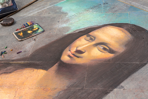 Forence, Italy, September 21, 2014: Drawing of the Mona Lisa in the streets of Florence directly on the pavement. Portrait of the Mona Lisa (La Joconde) is a masterpiece that Leonardo Devinci has painted between the years 1503 and 1519.