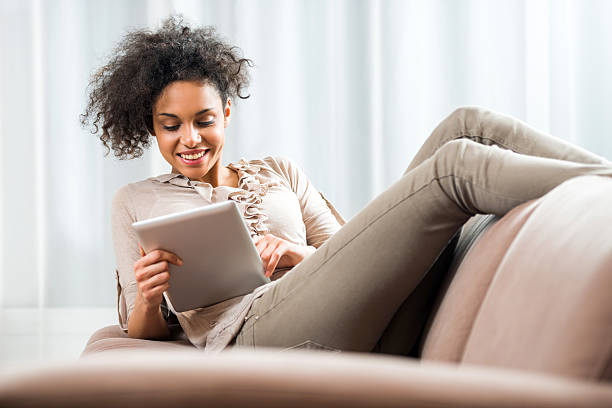 istock Smiling African American woman using touchpad at home. 487526440
