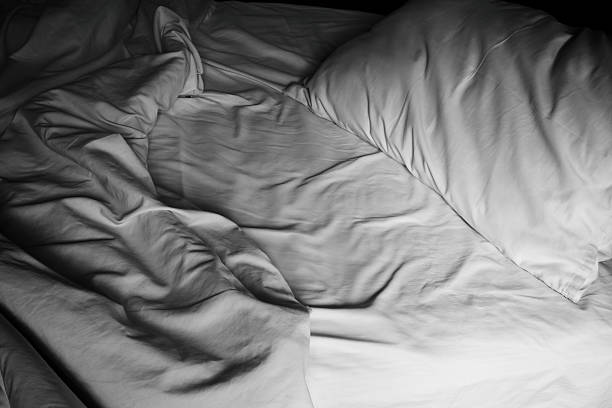 istock Messy white bed and pillow, in the morning 487526864