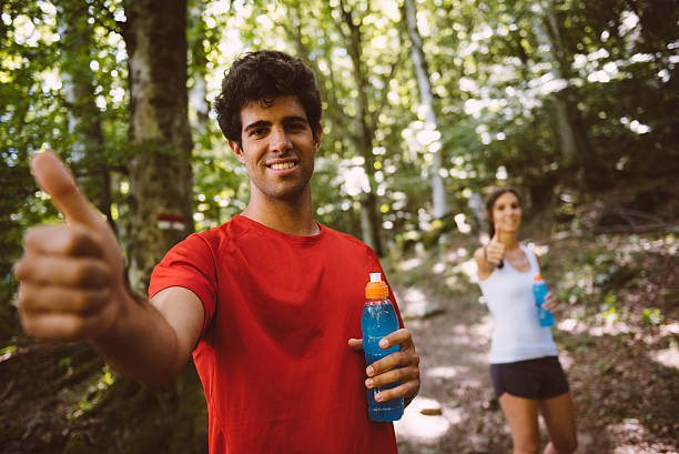 Two people pose on a trail with thumbs up stock photo