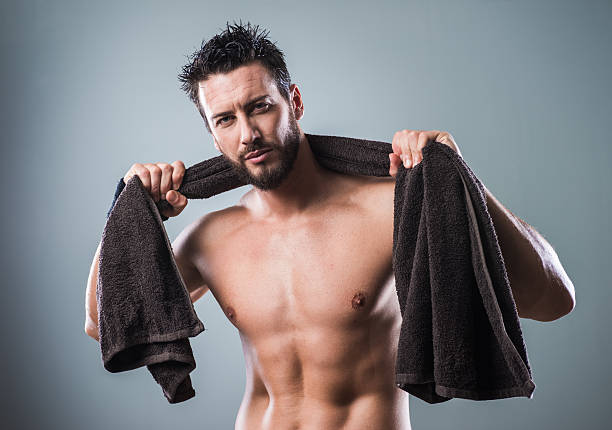 bella atletica uomo in posa con asciugamano - sex symbol male men shirtless foto e immagini stock