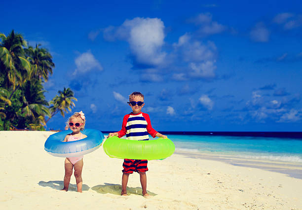 cute little boy and toddler girl play on beach cute little boy and toddler girl play on tropical beach family beach vacations travel stock pictures, royalty-free photos & images