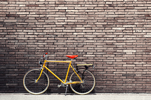 Retro bicycle on roadside with vintage brick wall background