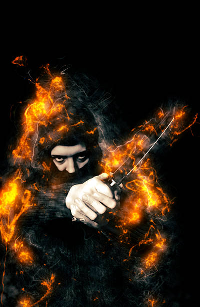 istock Hooded person with Ninja Knife in fire. 487536528