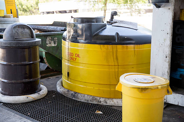 pojemniki na zużyte oleje silnikowe w centrum recyklingu - toxic waste radiation protection suit chemical protective suit zdjęcia i obrazy z banku zdjęć