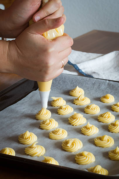 istock Unbaked cream puffs on parchment-lined baking sheet 487539372