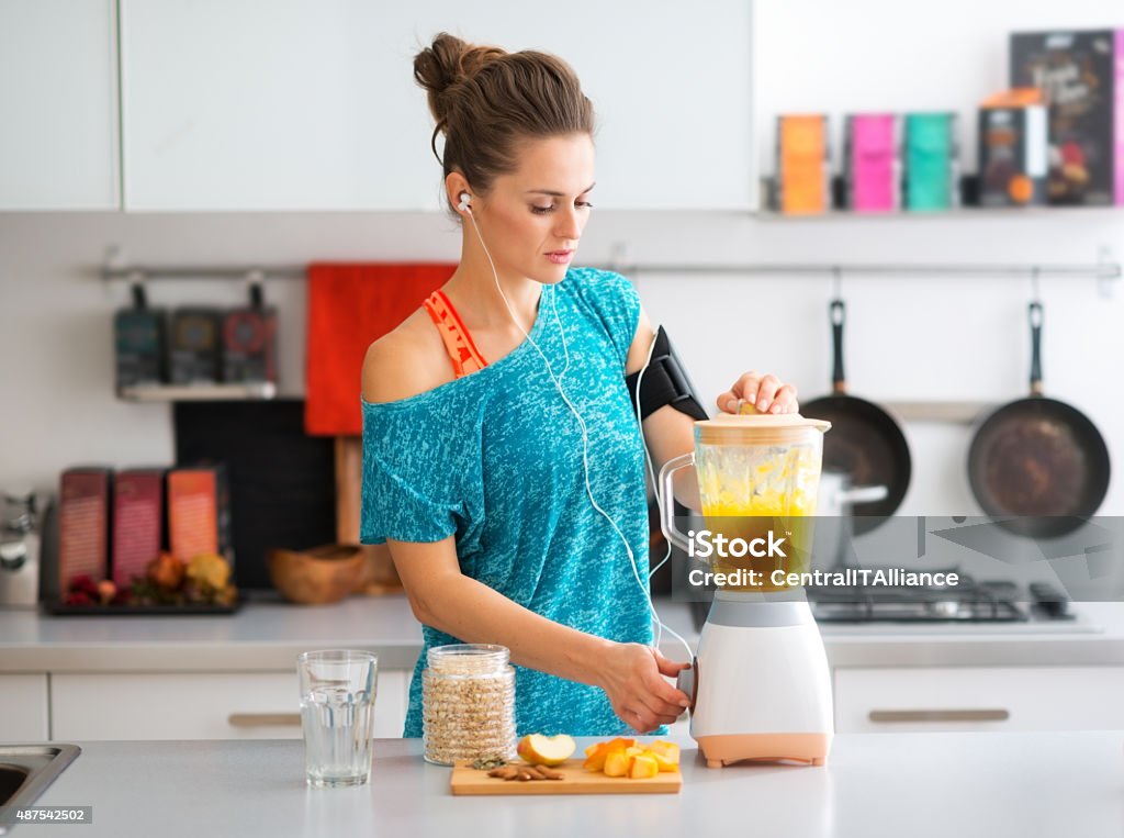 Fit mujer en cocina con un - Foto de stock de Licuadora libre de derechos