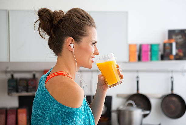 grande plano de ajuste mulher no perfil de iniciar a beber de smoothies - orange smoothie imagens e fotografias de stock