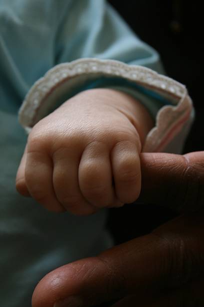 istock Baby hand holding grandfather's thumb 487543714