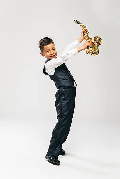 istock six years old boy brings saxophone over his head 487543748