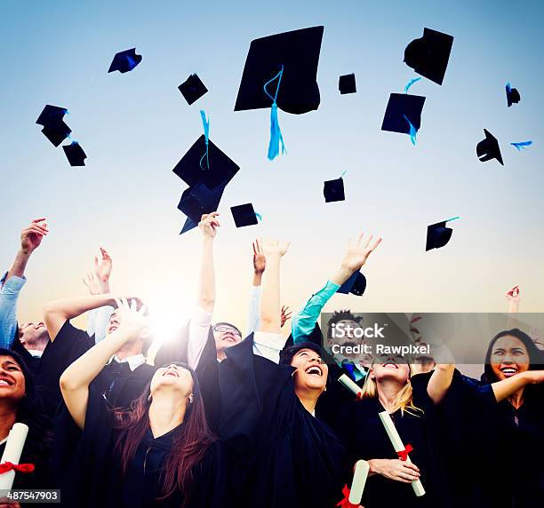 Smiling Students Throwing Graduation Caps In Air Stock Photo - Download Image Now - Graduation, Throwing, Mortarboard