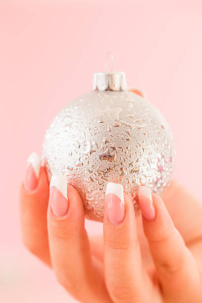 Silver bauble Young woman holding a bauble christmas nails stock pictures, royalty-free photos & images