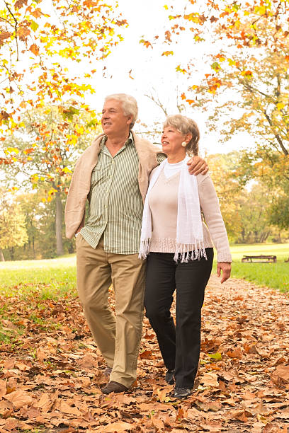 istock Senior Couple Walking In Park 487548601