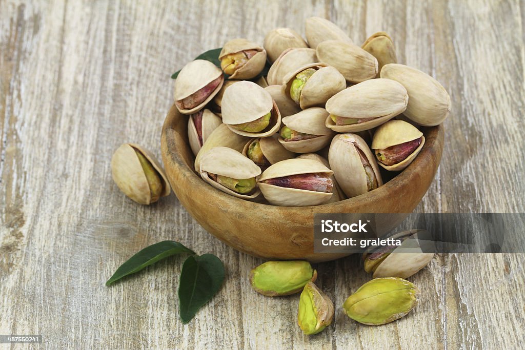 Pistachios in wooden bowl with copy space Pistachios with and without shell in wooden bowl with copy space Pistachio Stock Photo