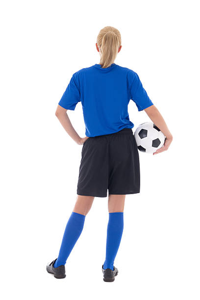 back view of female soccer player in uniform with ball stock photo