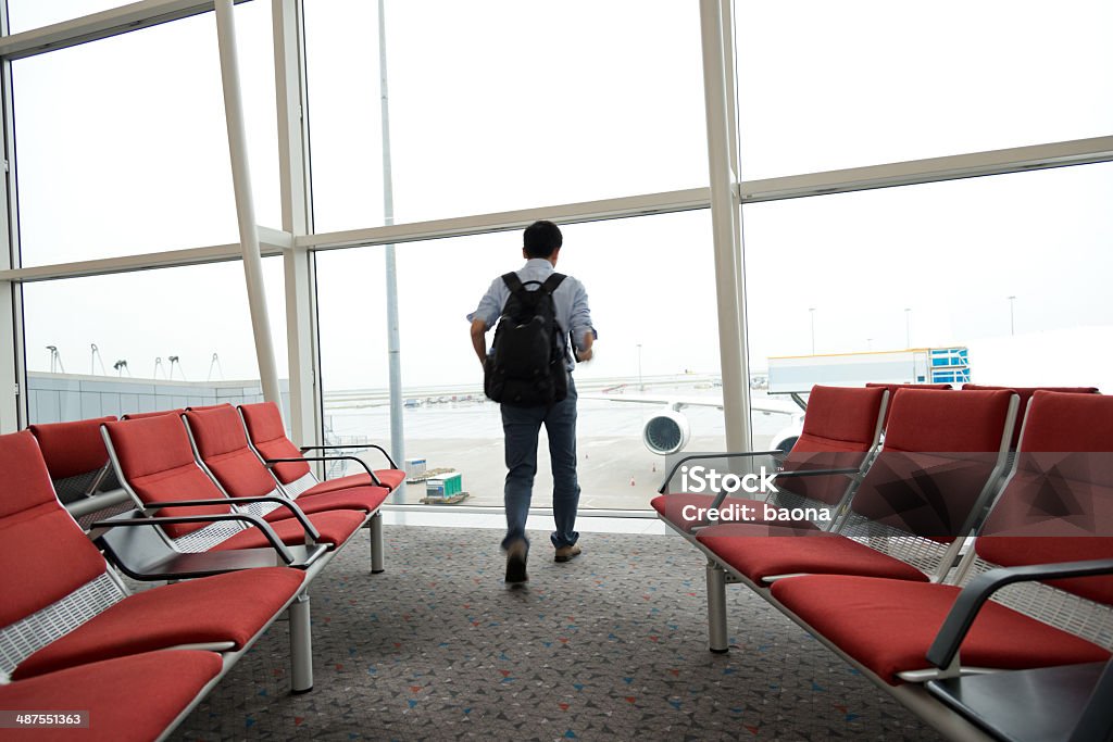 Departure Businessman waiting for his departure in the airport lounge Back Lit Stock Photo