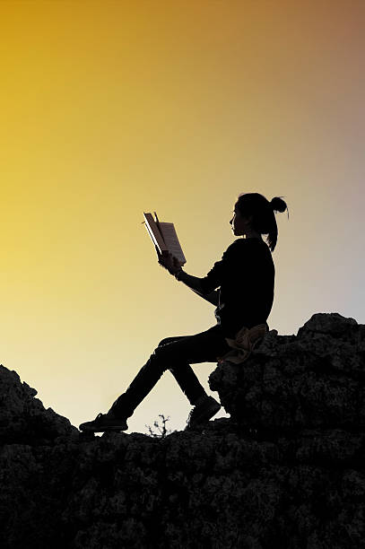 istock Young girl reading a book at sunset 487552927