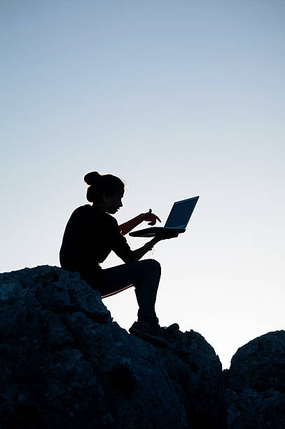 istock Girl working with laptop at sunset 487553015