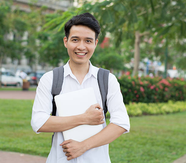 istock Happy smiling college student with laptop 487556490