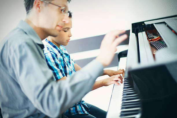 istock Little boy having piano class with his teacher. 487563120