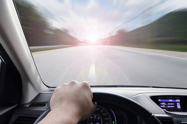 istock hand driving a car with speed on the street 487564470