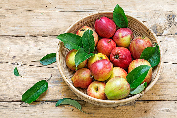 istock apples and leaves in a basket on a wooden table 487564610
