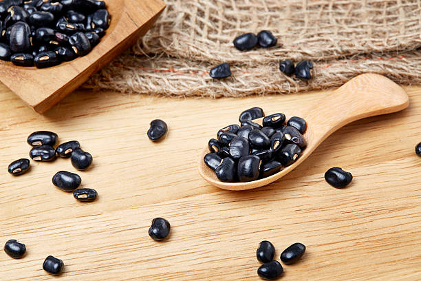 istock Black beans in wooden spoon 487565078