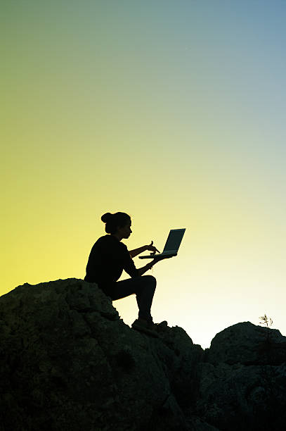 istock Girl working with laptop at sunset 487570073