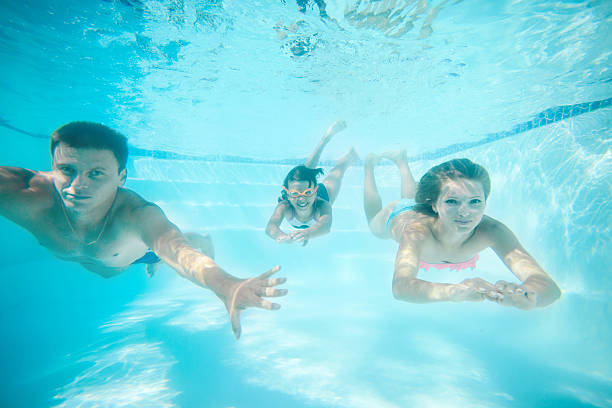 istock Parents and daughter swimming underwater 487580524