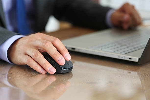 istock Hands of businessman in suit holding computer wireless mouse 487581912