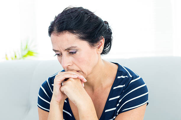 istock Unhappy woman sitting on the couch 487583330