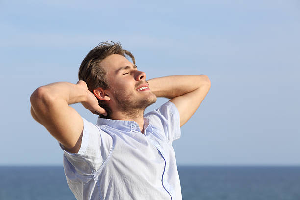 istock Happy young man breathing deep outdoor 487587789
