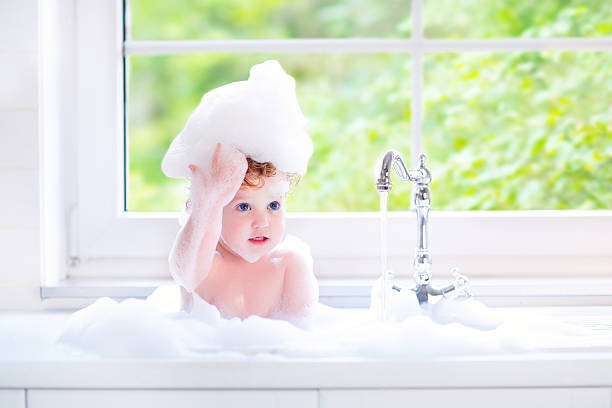 istock Pretty baby girl playing in a big kitchen sink 487590843