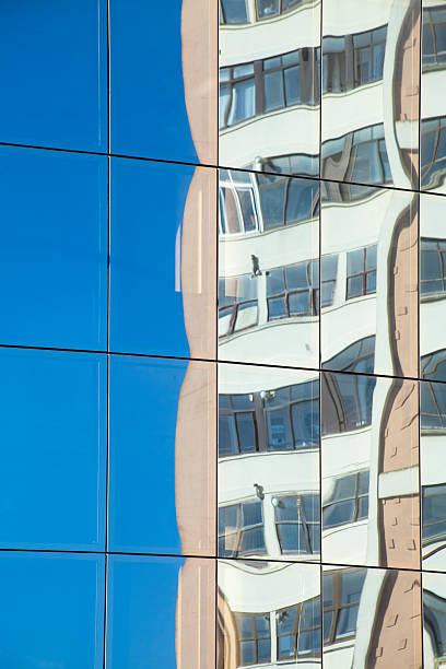 istock Building and blue sky reflection on glass office building facade. 487593294