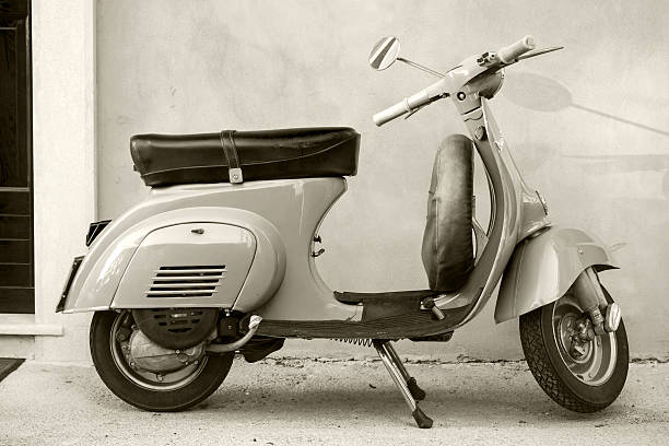 Gaeta, Italy - August 19, 2015: Classic yellow Vespa scooter stands parked near the wall