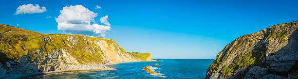 большой голубой лет�о небо над cove пляж cliffs panorama с видом на океан - beasch стоковые фото и изображения