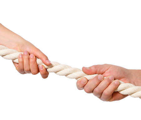 Male and female hands pulling the rope. Isolated on a white background. Can illustrate the concept of male - female confrontation.