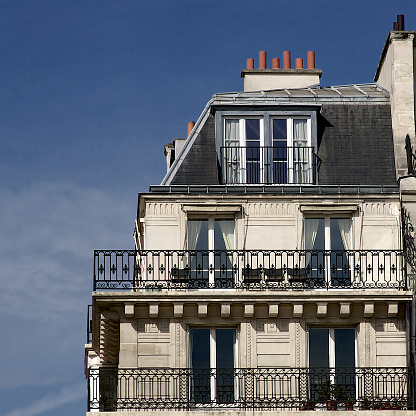 Paris apartment building facade, chimneys, rooftop and balconies, French architecture