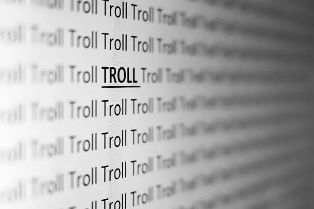 A pattern of the word 'TROLL' is shown from a side perspective. The picture symbolizes cyber bullies and internet trolls.