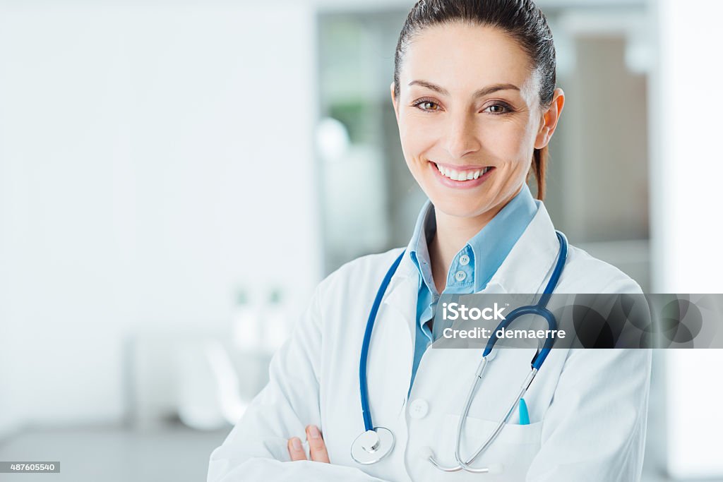 Confident female doctor posing in her office Confident female doctor posing in her office and smiling at camera, health care and prevention concept Female Doctor Stock Photo