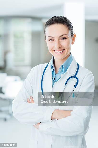 Confident Female Doctor Posing In Her Office Stock Photo - Download Image Now - Female Doctor, Doctor, Smiling