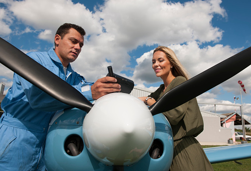 Woman and man pilot looking at gps map, preparing for flying