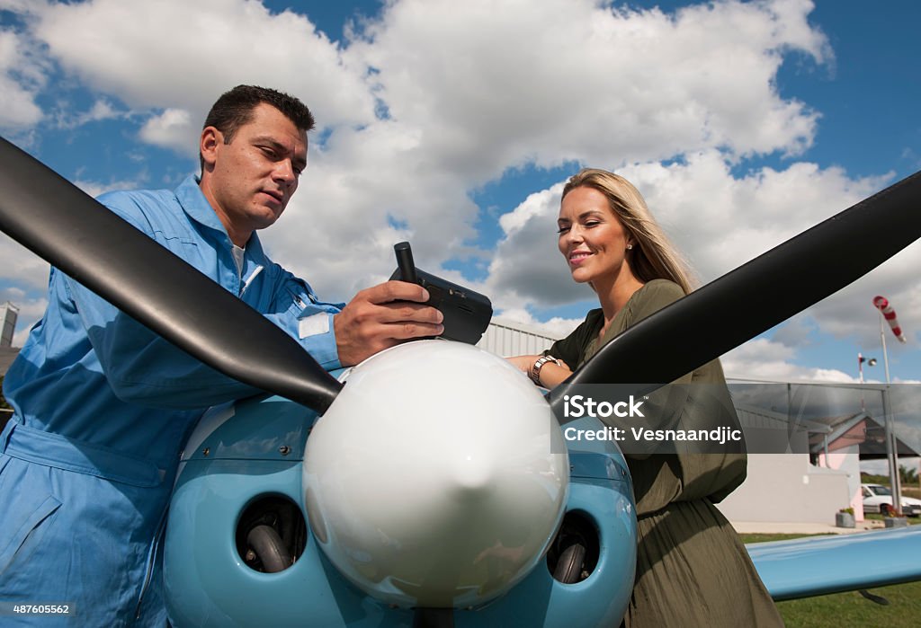 Woman and man pilot looking at gps, preparing for flying Woman and man pilot looking at gps map, preparing for flying Pilot Stock Photo