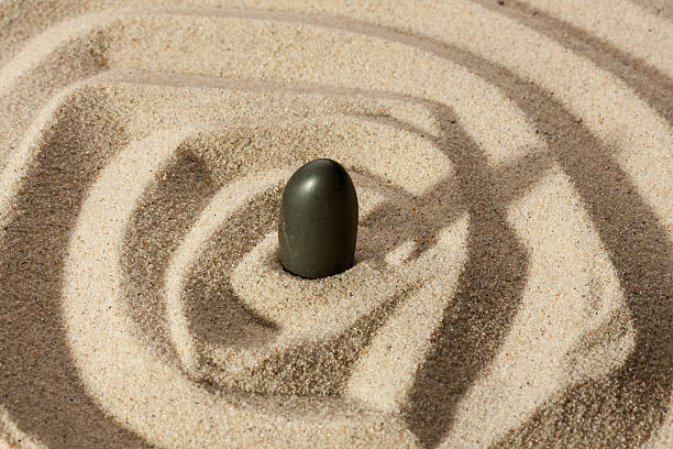 istock Black stone sticking out of the sand 487605721