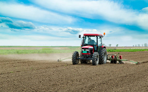 istock Young farmer sowing crops at field with pneumatic sowing machine 487606029