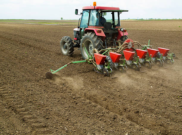 istock Young farmer sowing crops at field with pneumatic sowing machine 487606471